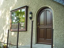 Holzhaustür und Blumenfenster